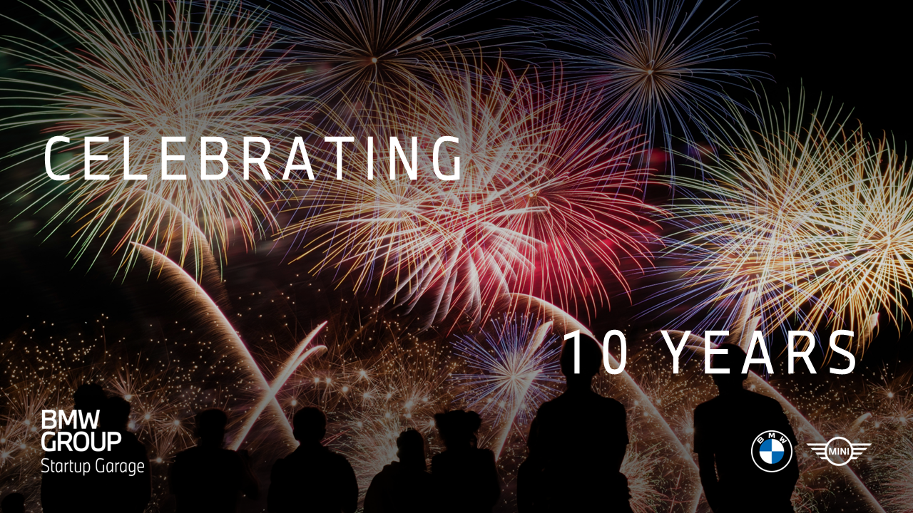 A group of people standing in front of a night sky illuminated by colorful fireworks.