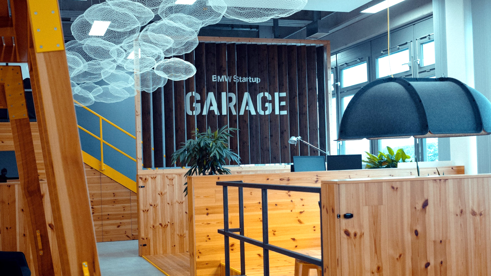 A group of four young BMW employees are all laughing as they look at the tablet belonging to one of the two women in the group.