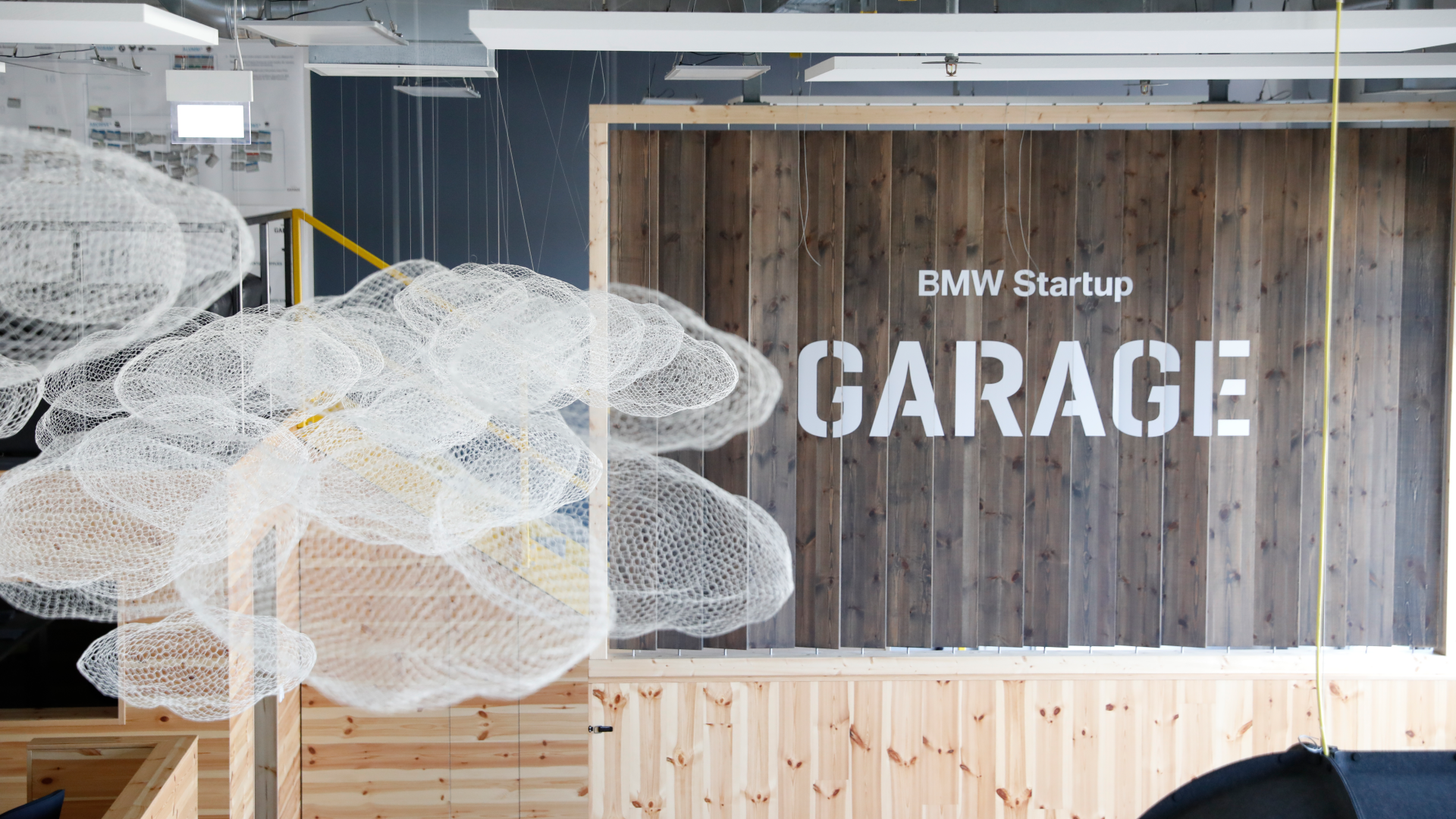 A group of four young BMW employees are all laughing as they look at the tablet belonging to one of the two women in the group.