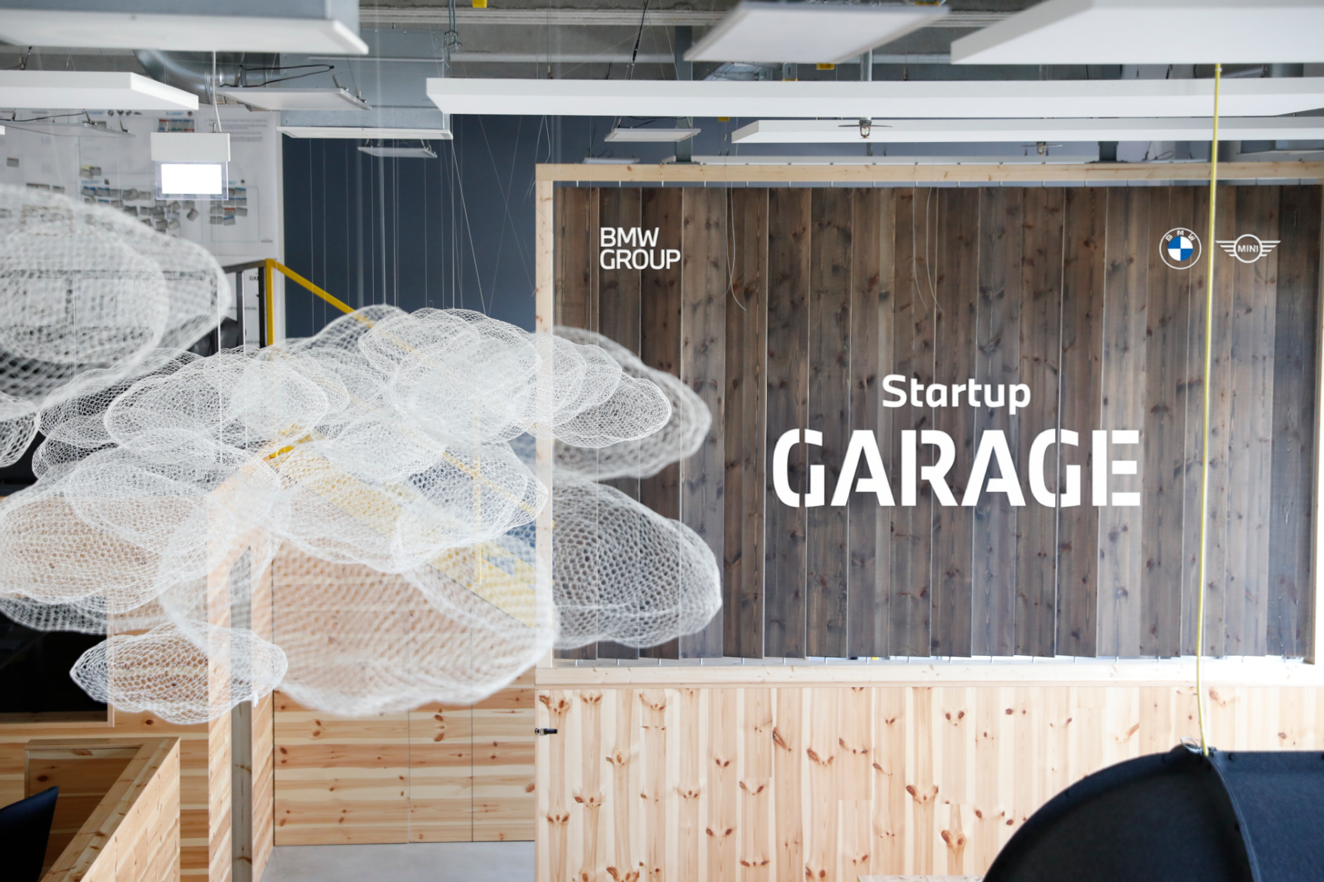 A group of four young BMW employees are all laughing as they look at the tablet belonging to one of the two women in the group.