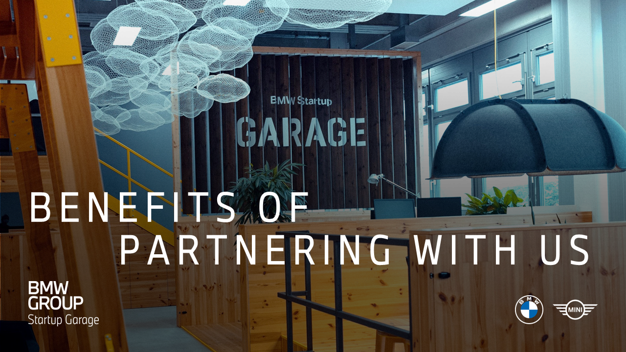 A modern office interior with wooden furniture, plants, and contemporary lighting elements creating an open and collaborative atmosphere.