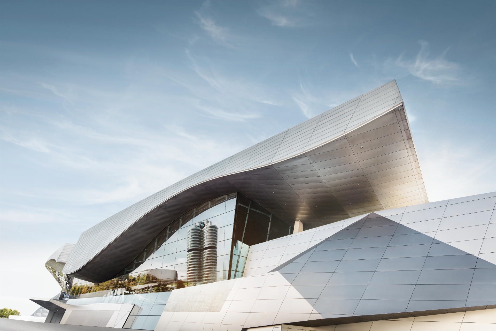 We see a photo collage of various BMW buildings such as BMW Welt and the BMW Four-Cylinder Building.