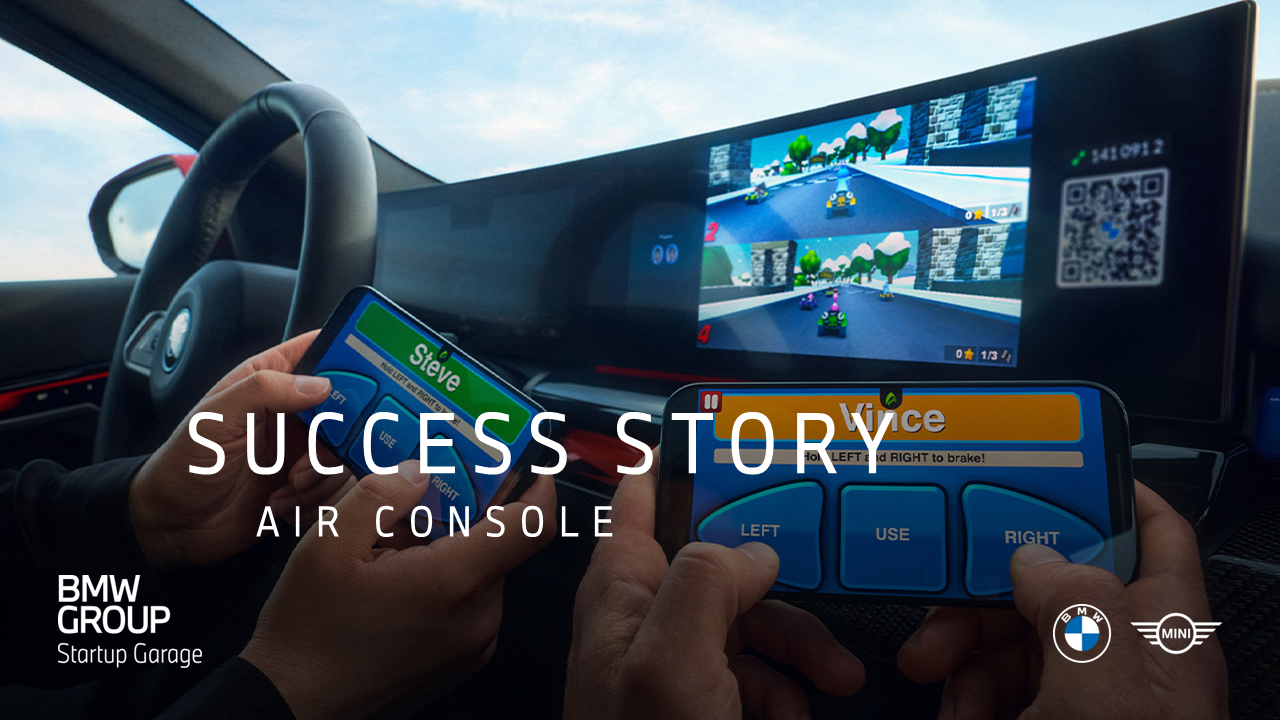 Two people inside a car use smartphones as controllers to play a racing game displayed on the vehicle’s dashboard screen.